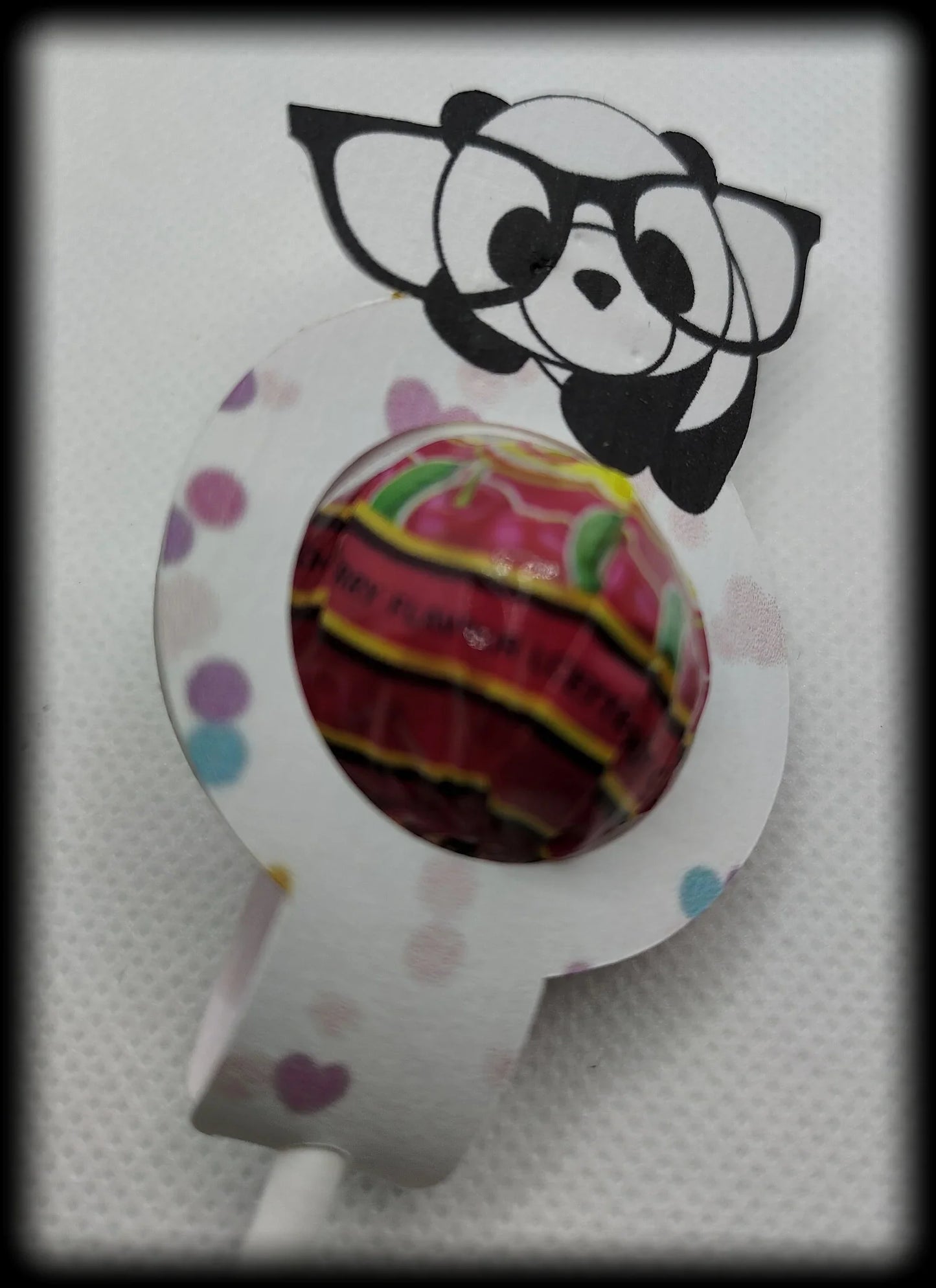 Colorful lollipop with panda and glasses paper holder on white background