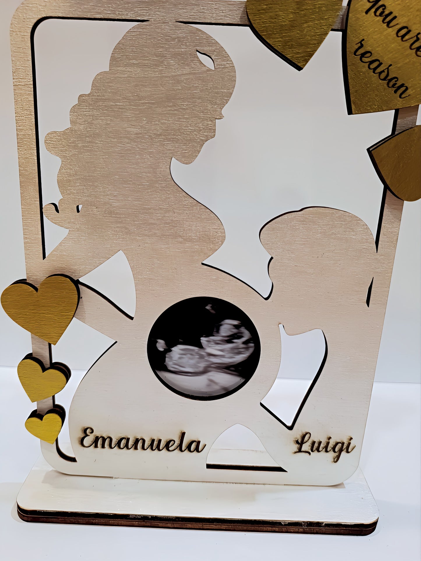 Wooden silhouette of pregnant woman and child with ultrasound photo, names Emanuela and Luigi, gold hearts