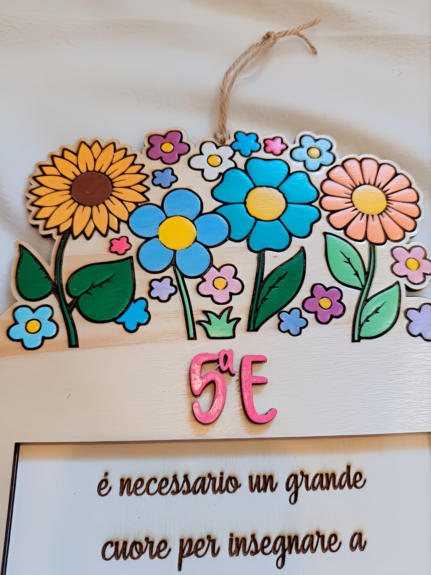 Colorful floral classroom sign with '5a E' and Italian teaching quote on wooden plaque