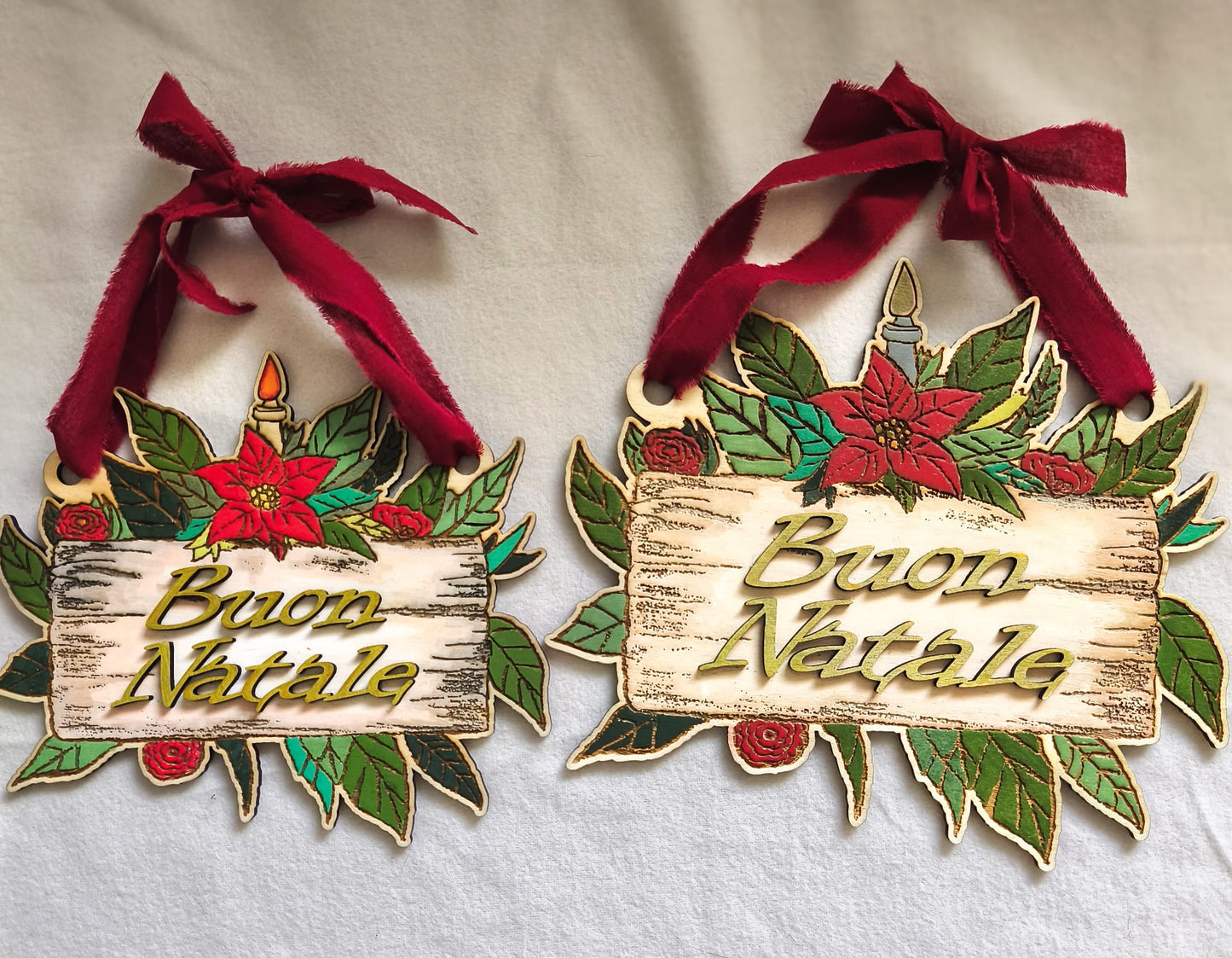 Two wooden Buon Natale Christmas signs with poinsettias, leaves, red bows, and candle design