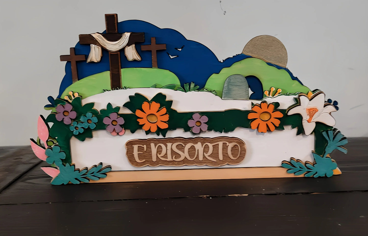 Easter resurrection scene wood decor with flowers, crosses, empty tomb, and 'E RISORTO' text