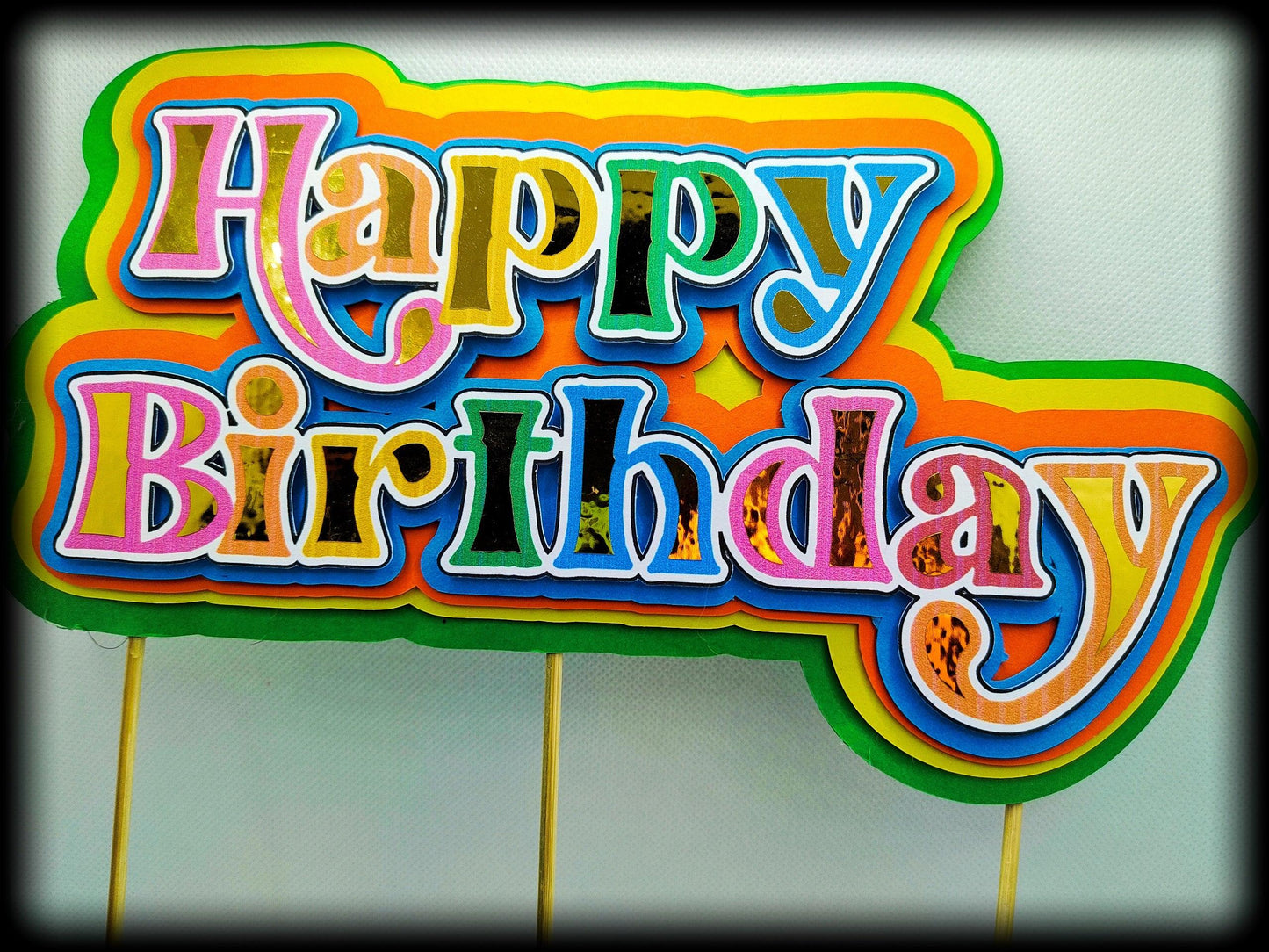 Colorful Happy Birthday sign with vibrant layered letters on white background