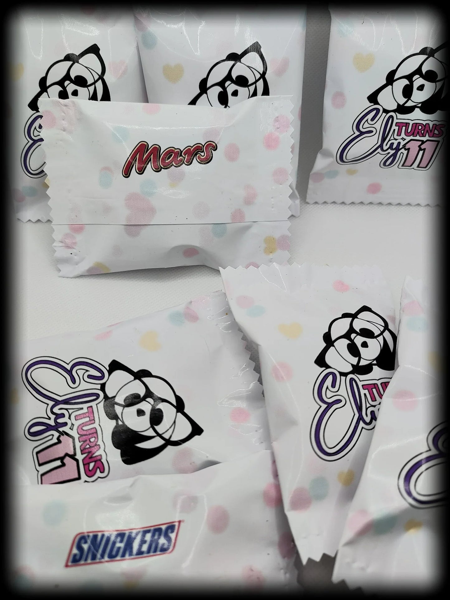 Custom candy wrappers with cartoon bear, Mars and Snickers logos, pastel heart pattern
