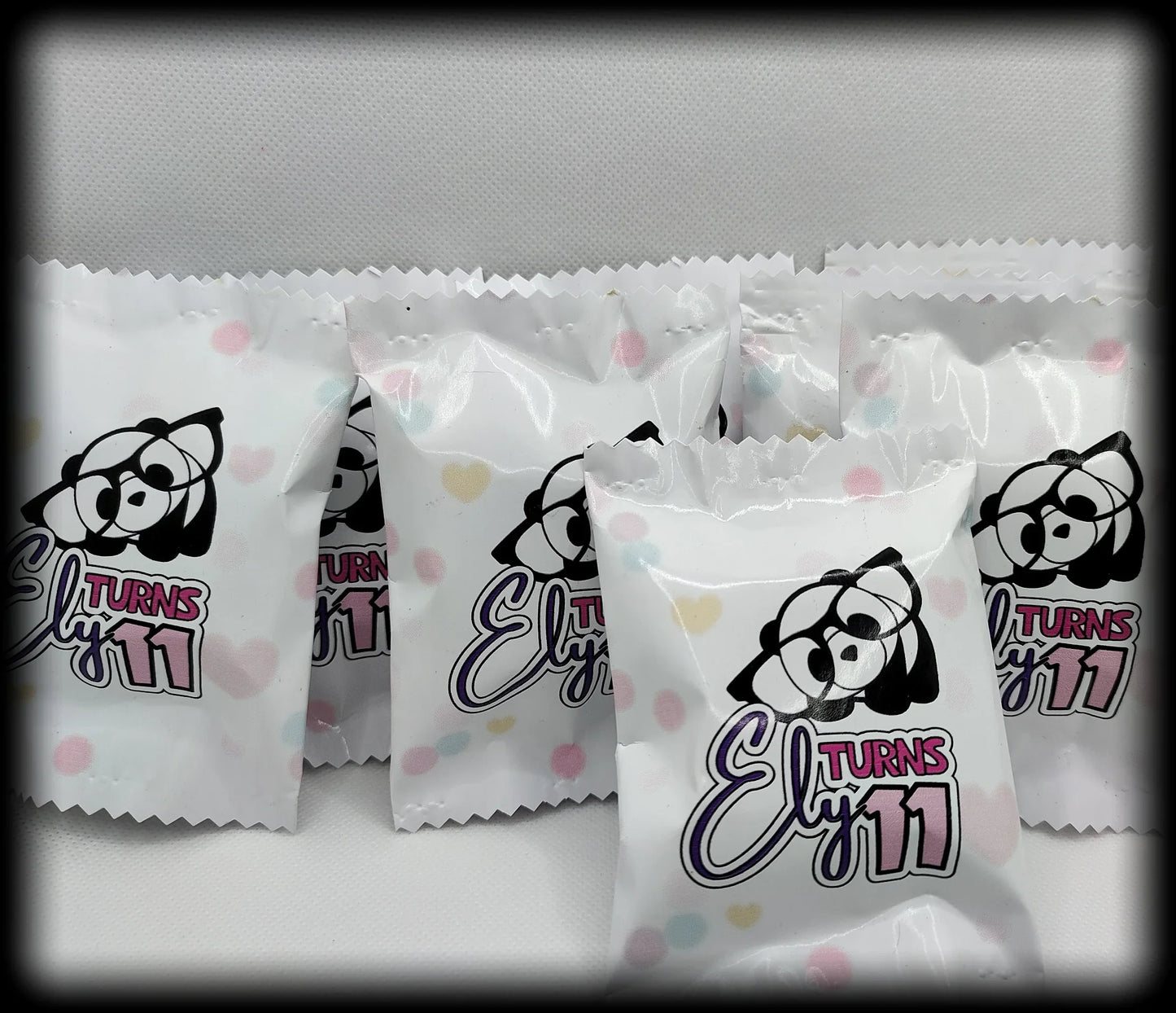 Cute panda-themed Ely Turns 11 birthday party favor bags with pastel polka dots