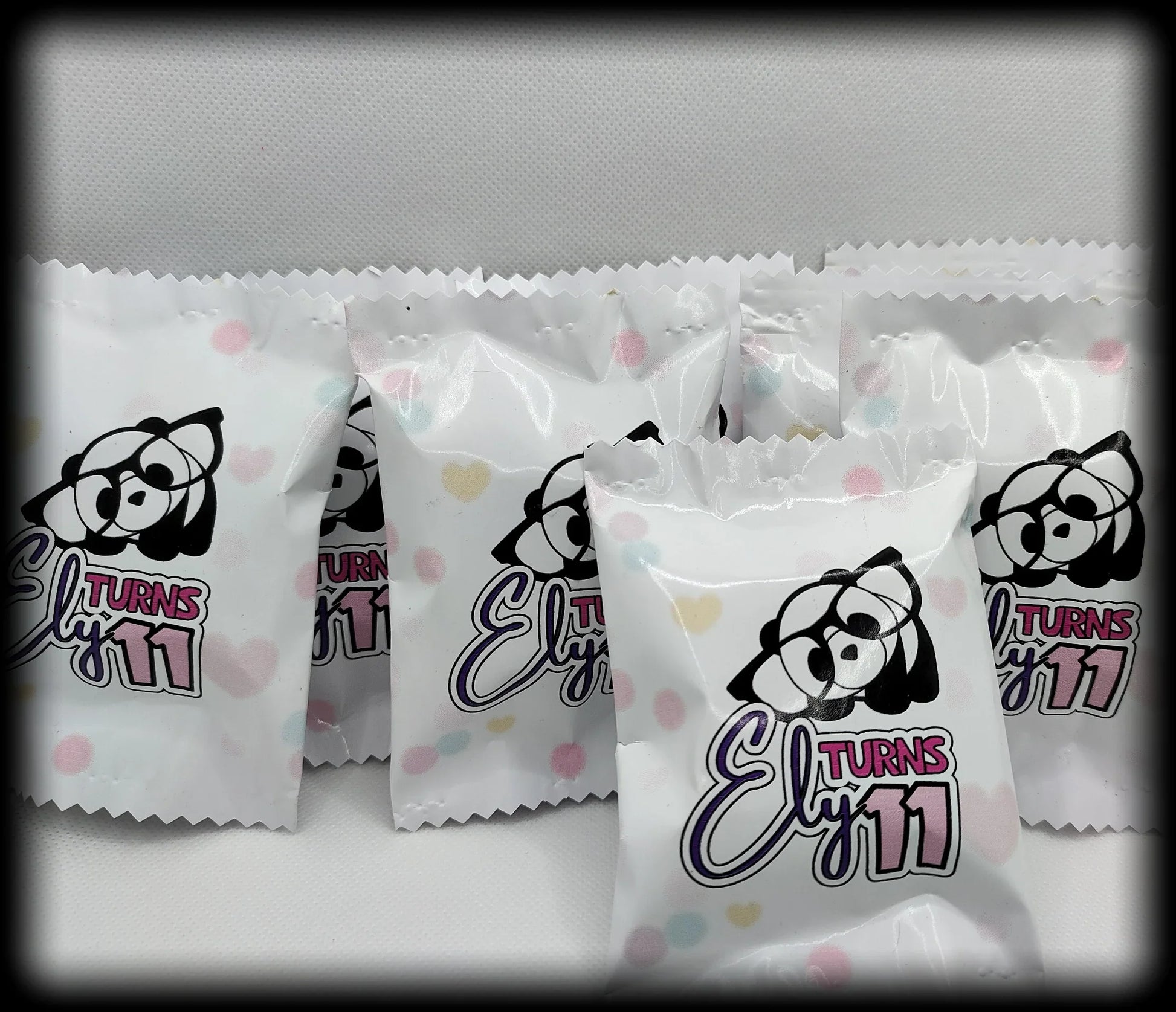Cute panda-themed Ely Turns 11 birthday party favor bags with pastel polka dots