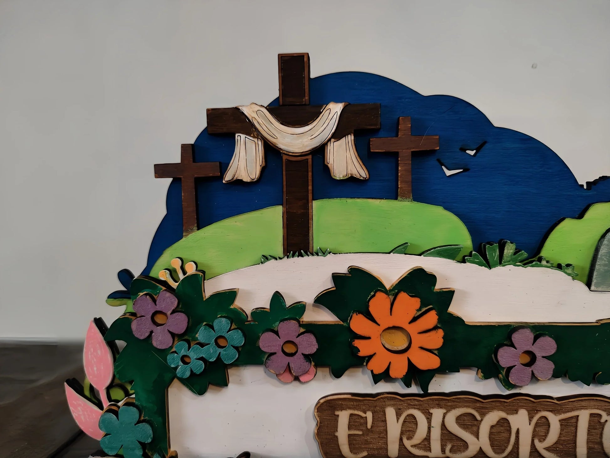 Easter wooden sign with three crosses on a hill, colorful flowers, and birds in the sky