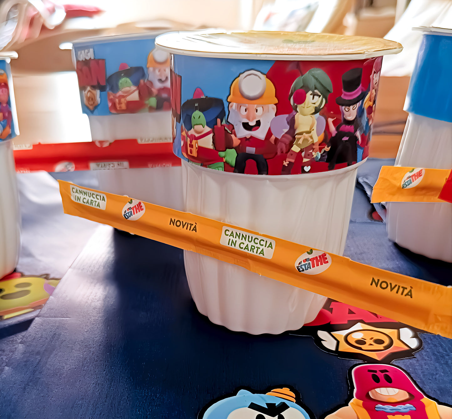Estathé cup with Brawl Stars characters, yellow paper straw wrapper, and colorful packaging