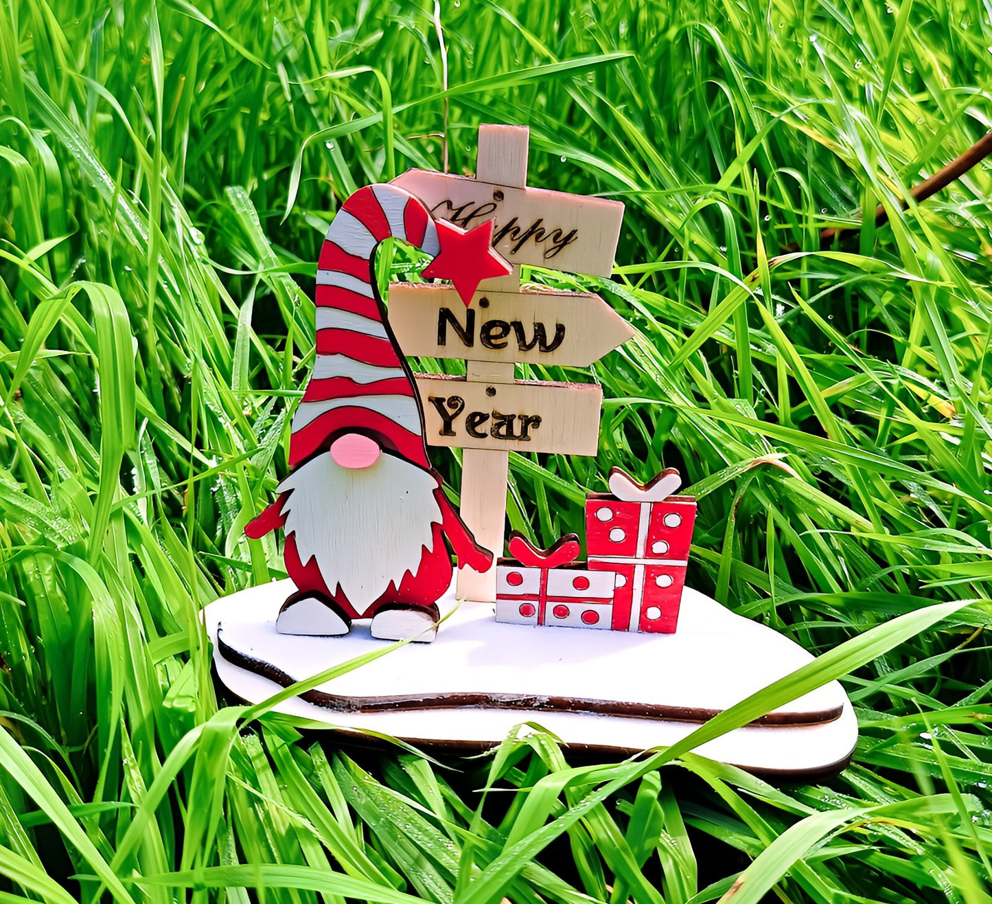 Festive gnome with Happy New Year sign and gift boxes on grass background