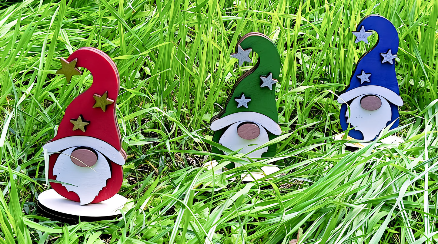 Colorful wooden gnome garden decorations with star hats amid tall green grass