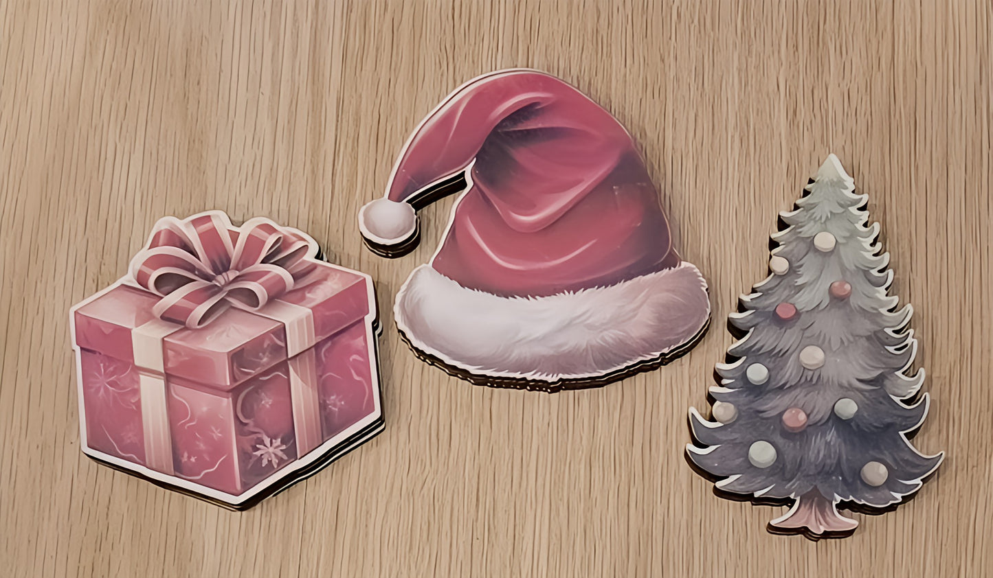Christmas stickers of a gift box, Santa hat, and Christmas tree on wooden background