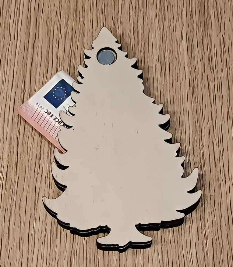 Wooden Christmas tree ornament on table with a card partially underneath