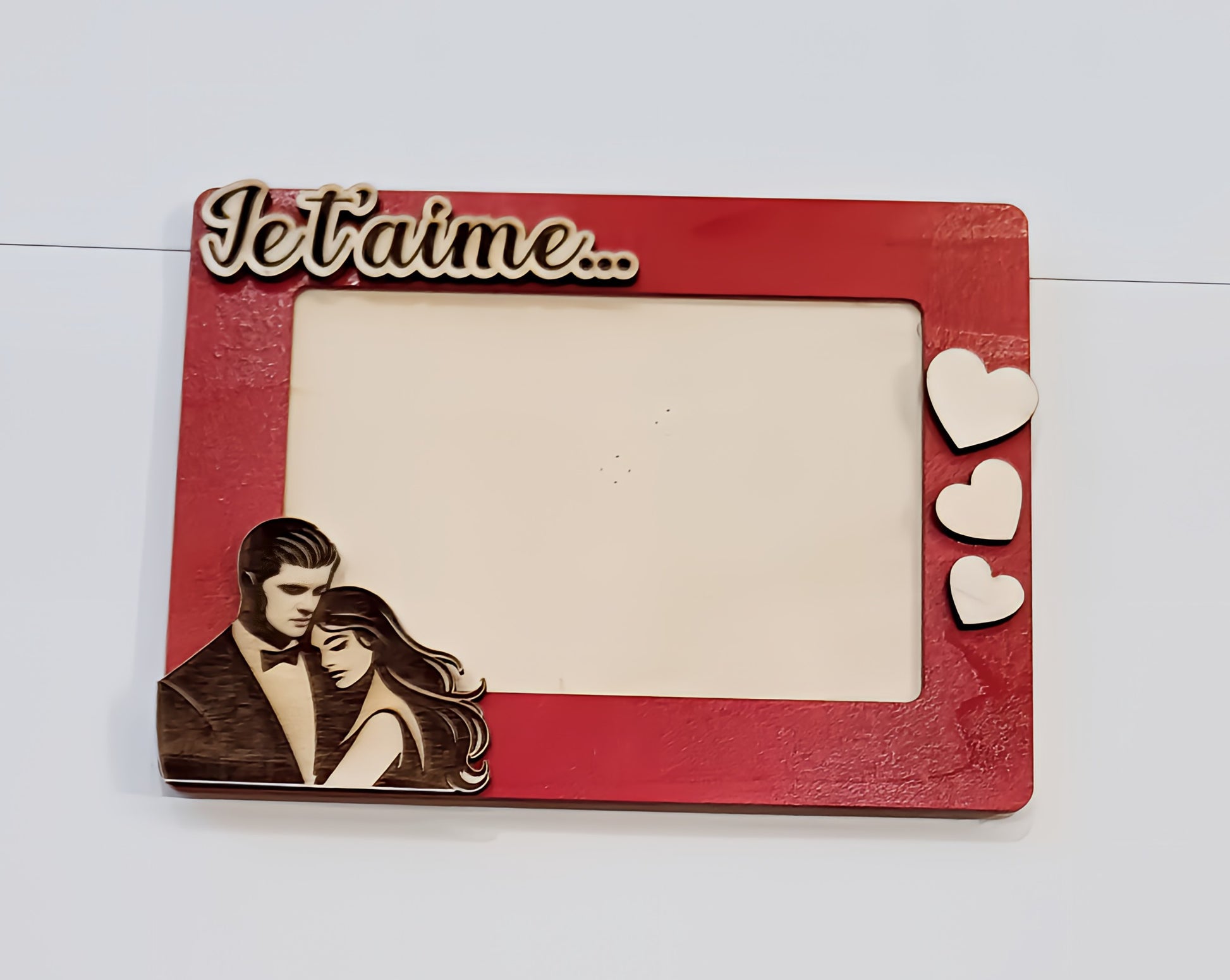 Red romantic photo frame with Je t'aime text, three hearts, and couple illustration