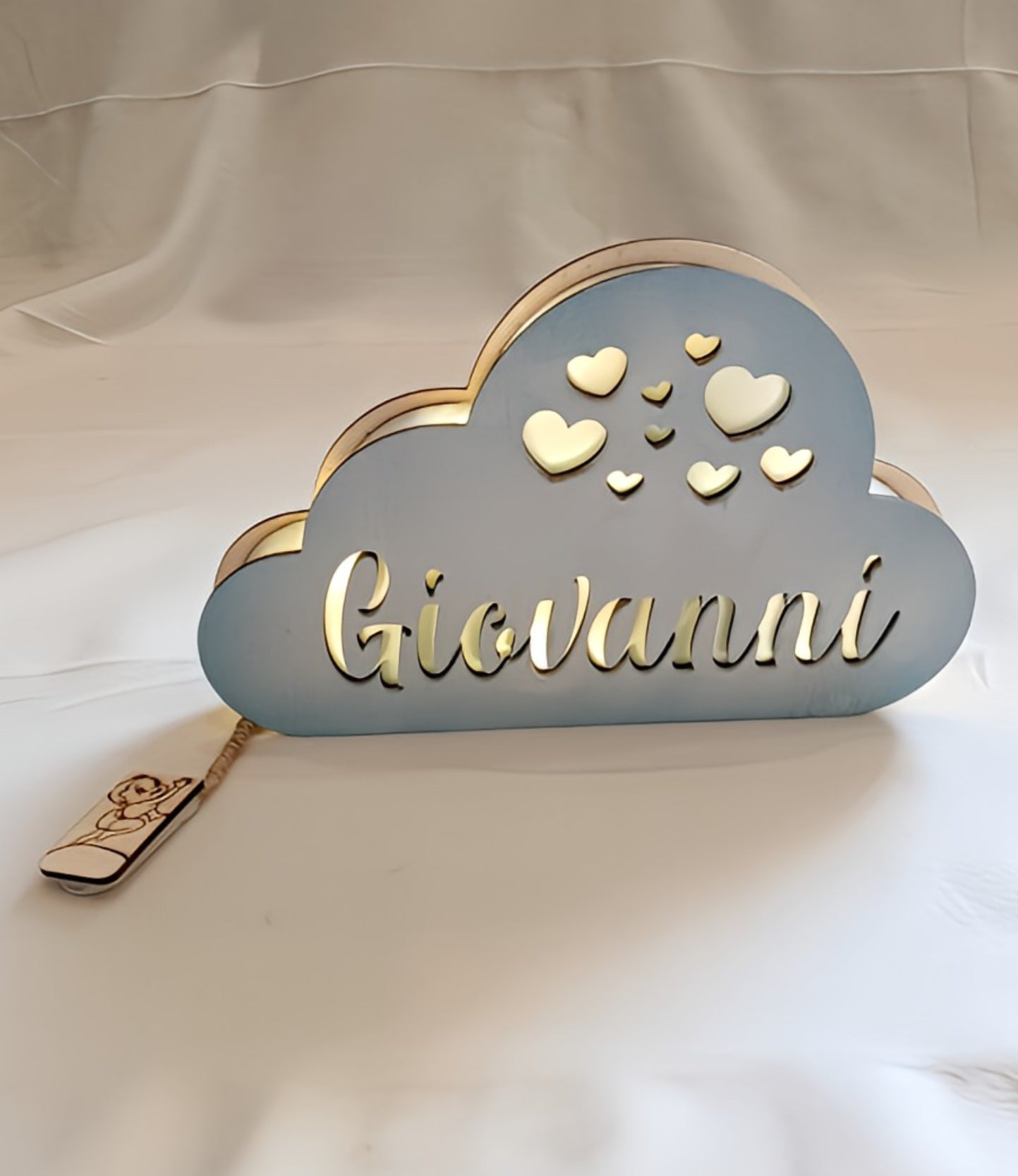 Personalized cloud-shaped night light with cutout hearts and name Giovanni on white background