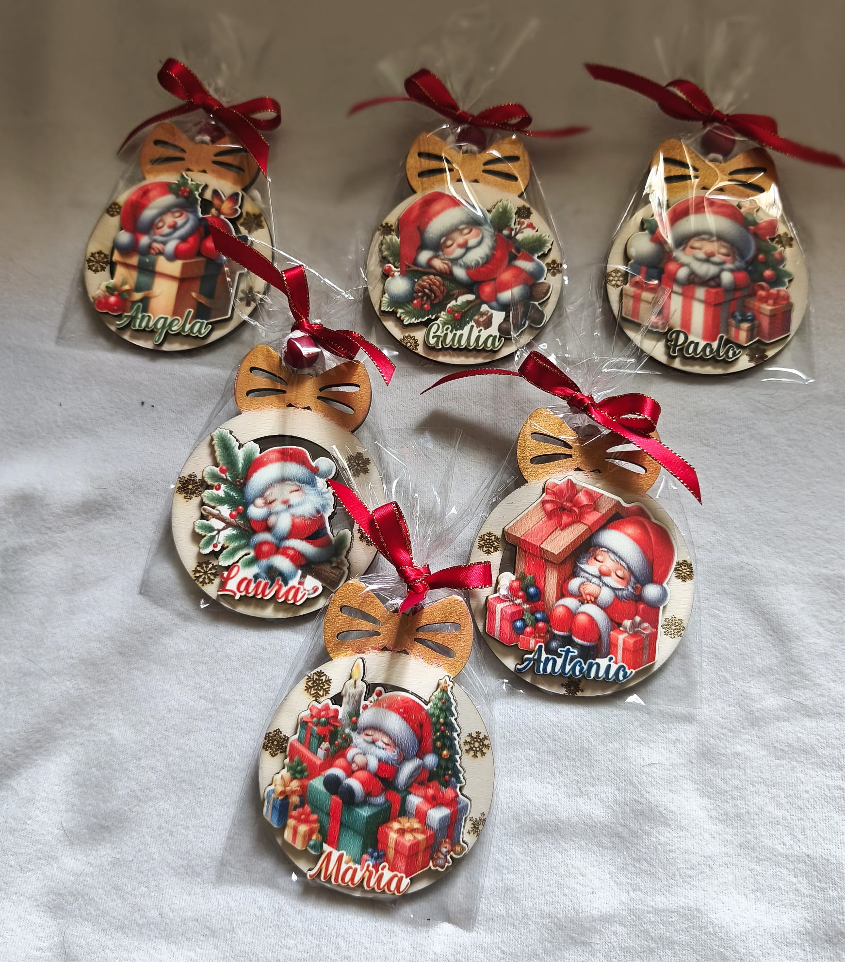 Personalized wooden Christmas ornaments with Santa Claus, gift boxes, and red bows