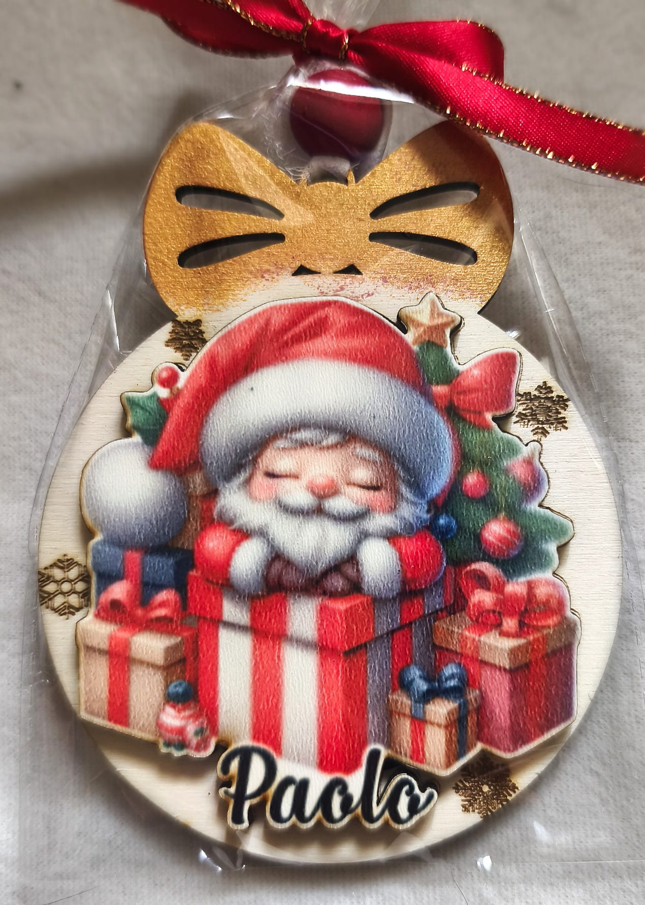 Personalized Christmas ornament with Santa in a gift box, presents, and Paolo name tag