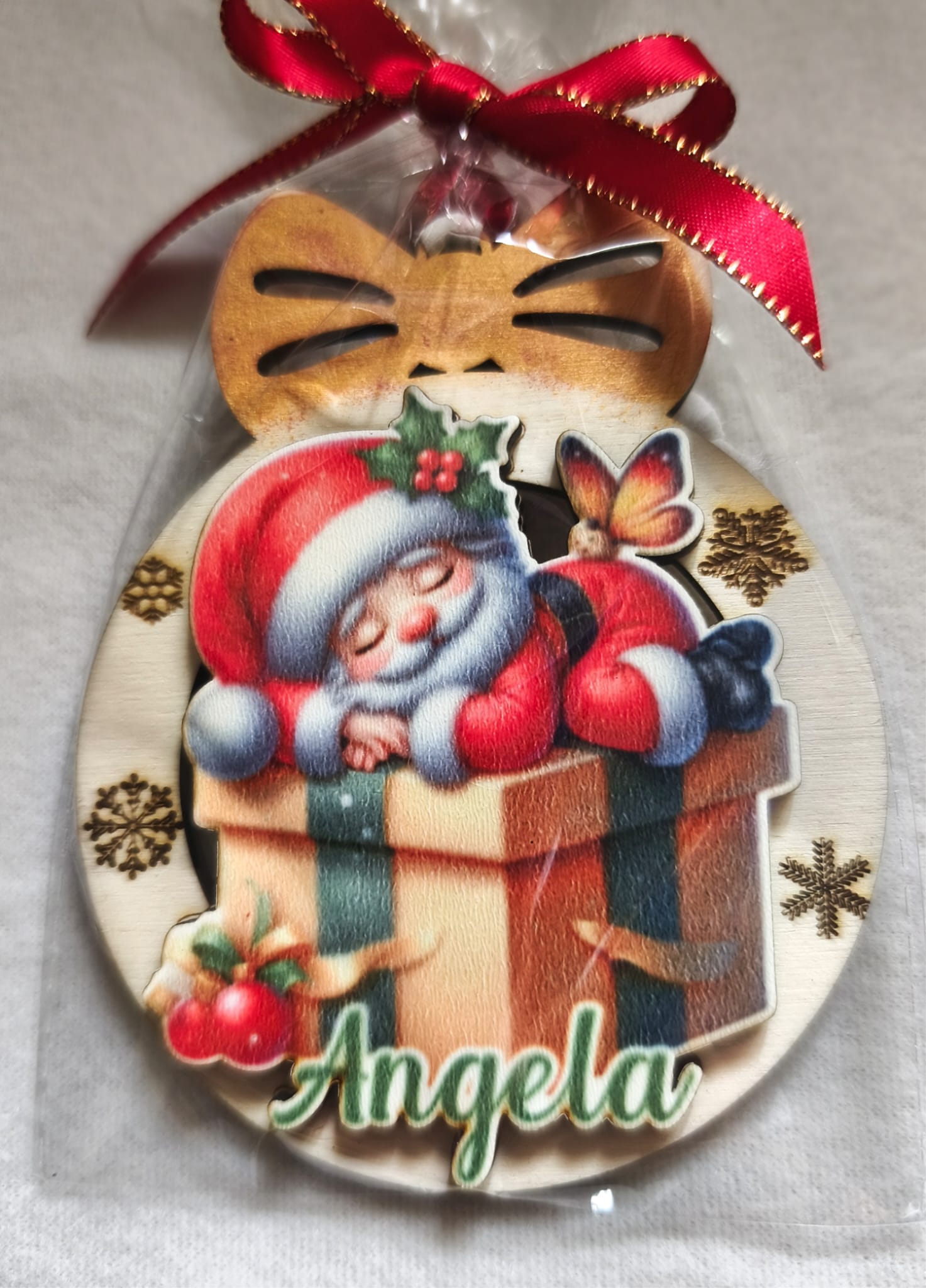 Personalized Christmas ornament with Santa Claus sleeping on a gift, red ribbon, name Angela