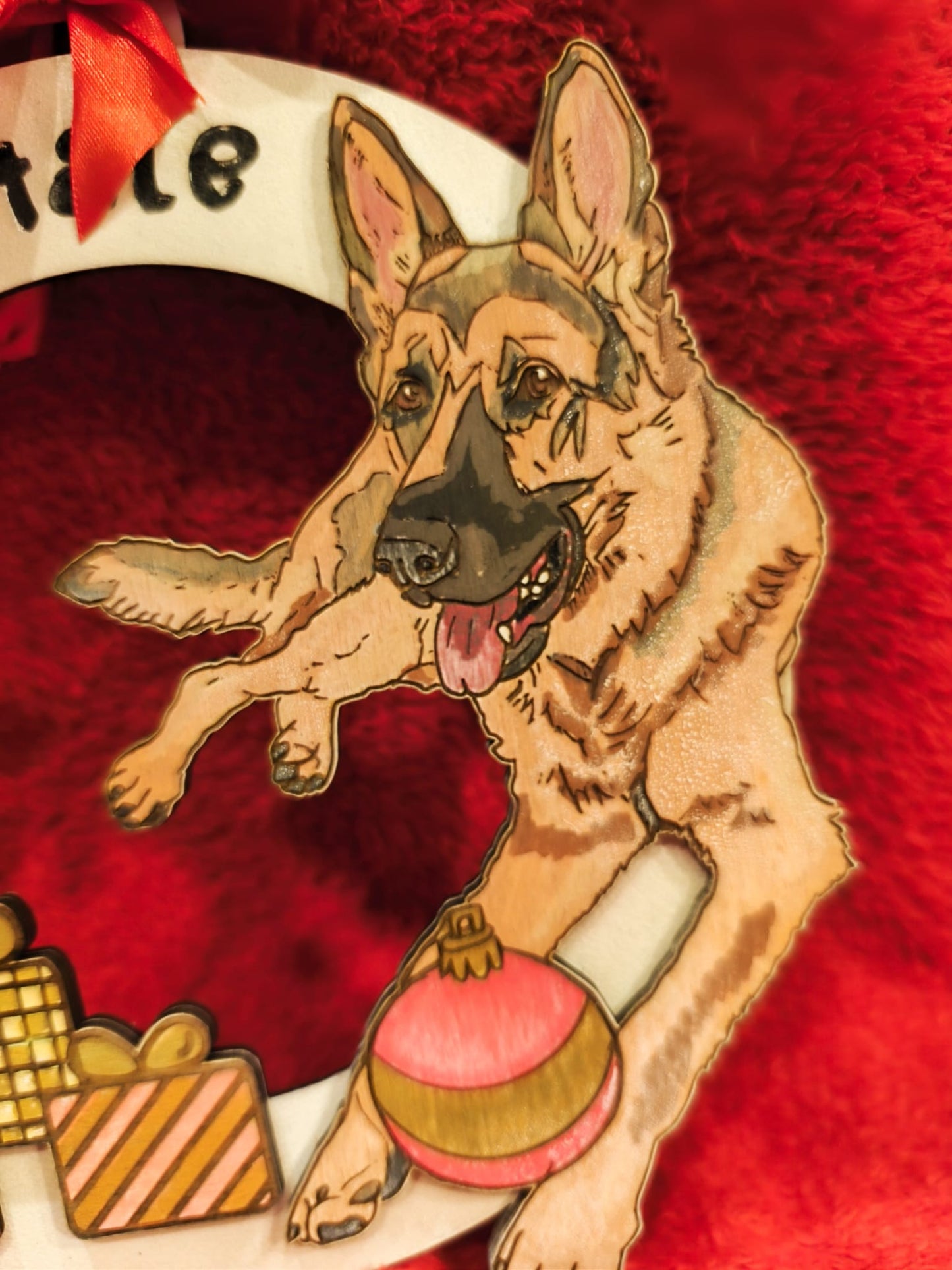 German Shepherd wooden ornament with gifts and bauble on red festive background