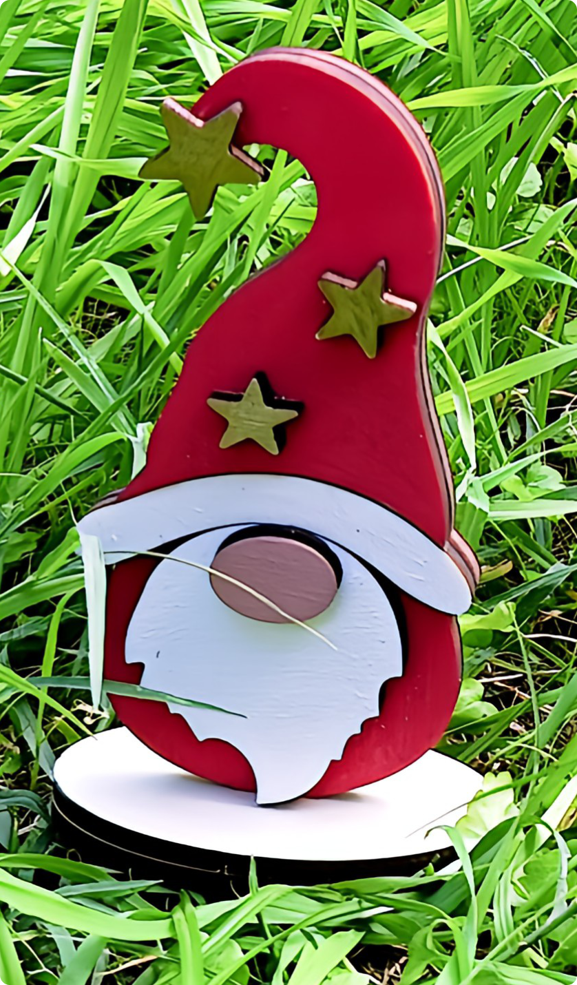 Wooden gnome garden ornament with red hat and gold stars on green grass