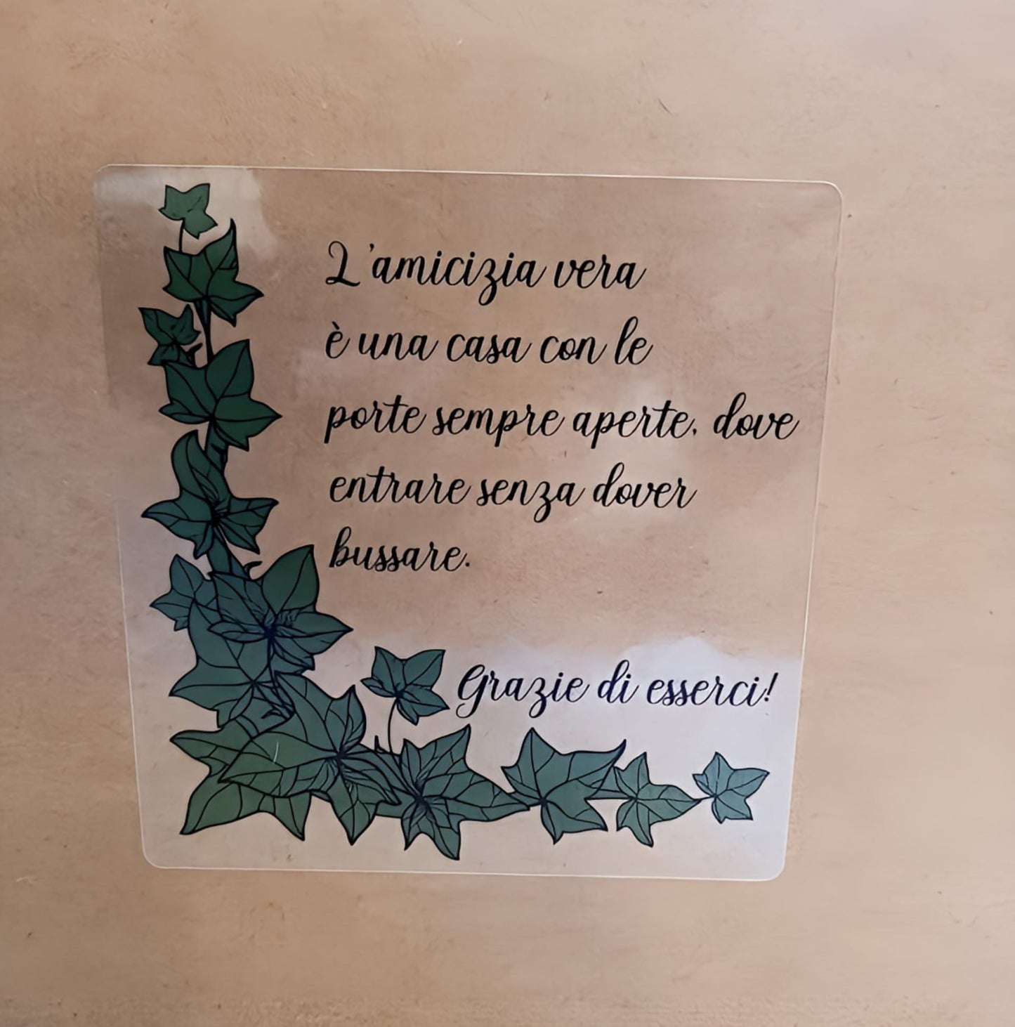 Italian friendship quote sign with green ivy vines on beige wall, appreciation message